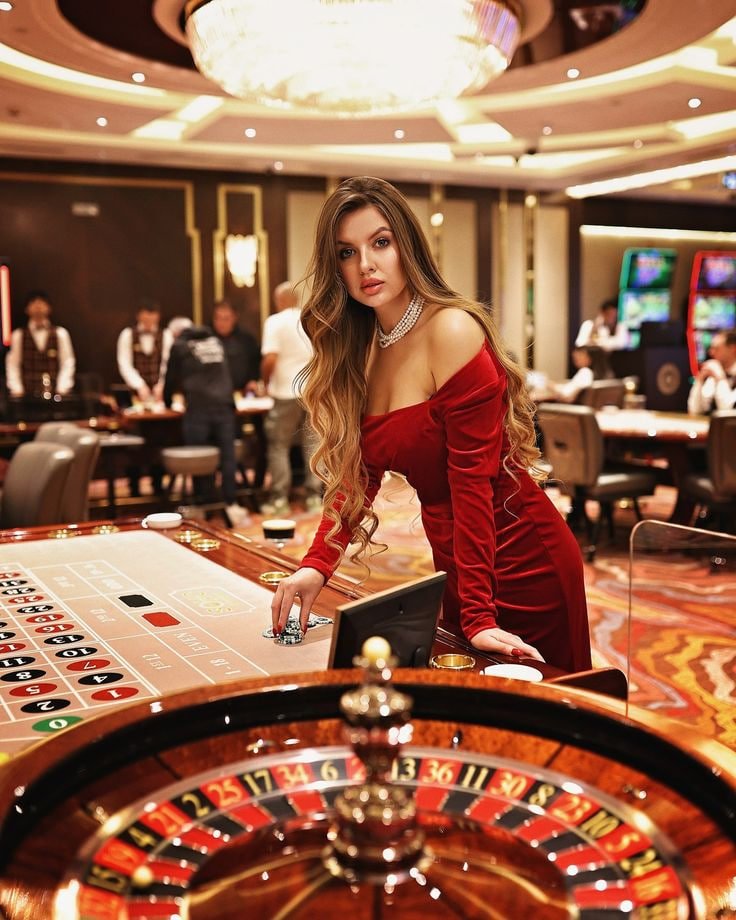 Live casino dealer at a blackjack table in an online streaming studio